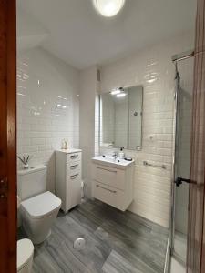 a white bathroom with a toilet and a sink at Paseo de los Castaños con vistas in Aguadulce