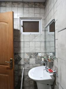 a bathroom with a white sink and a window at Luxe 1 Bedroom Apartment in Doha emporium B-17, Margalla views in Islamabad