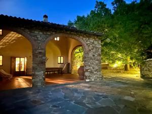 an outdoor patio with an archway at night at Podere Fichereto Tuscany Apartment in Florence countryside in Scandicci