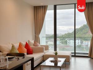 Ban Thung NgaiにあるElegant Private Suite Room in Hat Yaiのソファと大きな窓のあるリビングルーム