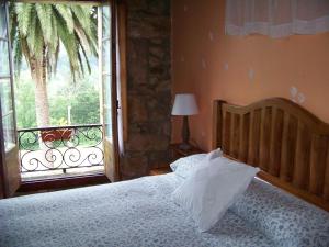 a bedroom with a bed and a large window at B&B El Jardín de Aes in Puente Viesgo