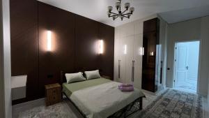 ein Schlafzimmer mit einem Bett und einem Kronleuchter in der Unterkunft Шикарная 2х комнатная квартира ЖК БИРЛИК in Schymkent