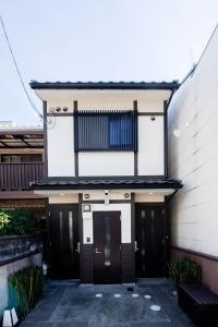 een gebouw met zwarte deuren en een blauw rooster bij Noir Toji Inn in Kyoto
