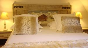 een bed met witte lakens en kussens in een slaapkamer bij Gîte Maison des Vignerons in Riquewihr