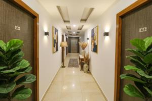 a corridor of a house with plants in the hallway at FabExpress Dolphin International - Nr IGI Airport New Delhi in New Delhi