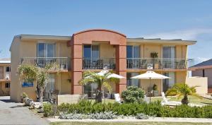 a building with chairs and umbrellas in front of it at Ocean View Motel in Perth