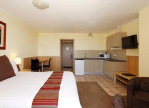a hotel room with a bed and a kitchen at Ocean View Motel in Perth
