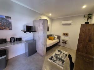 a small living room with a couch and a kitchen at Die Kantoor in Upington