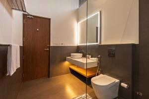 a bathroom with a white toilet and a sink at Kazuri in Alleppey