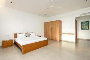 a bedroom with a bed and a wooden cabinet at Kazuri in Alleppey