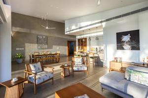 a living room with furniture and a dining room at Kazuri in Alleppey