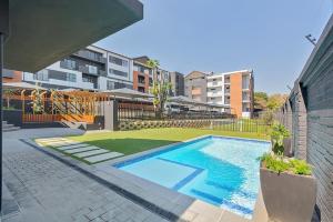 a swimming pool in front of a building at Opulent Escape Bryanston in Johannesburg