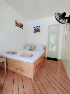 a bed in a room with a wooden floor at Bool Perimeter's Inn in San Juan
