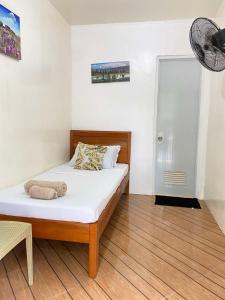 a bedroom with a bed with white sheets and a fan at Bool Perimeter's Inn in San Juan