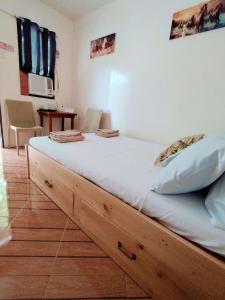 a bed with a wooden frame in a room at Bool Perimeter's Inn in San Juan