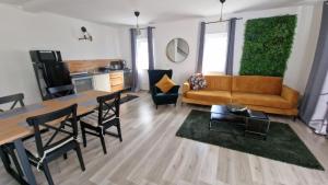 a living room with a couch and a table and chairs at Schicke neue Ferienwohnung in Bremen