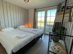 a bedroom with a bed with a ladder and a window at De Tuinkamer in Egmond aan den Hoef