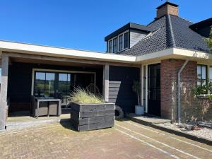 a house with a patio with a table in it at De Tuinkamer in Egmond aan den Hoef +14 photos