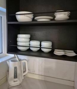 a shelf with white bowls and plates and a blender at Roome House in Seoul +23 photos