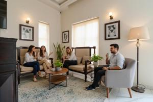 a group of people sitting in a living room at FabHotel K9 Villa in Ludhiana