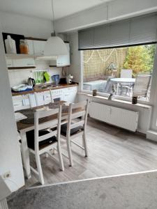 a kitchen with a table and chairs and a window at Apartment am Rodelberg in Braunlage