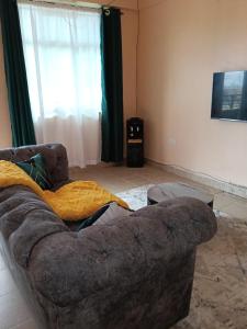 een bank in een woonkamer naast een raam bij Lakesong Haven BNB, Naivasha, Kenya in Naivasha