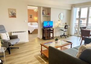 ラマルー・レ・バンにあるLe Coeur de Lamalouのソファとテーブル、テレビのあるリビングルーム