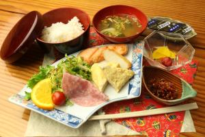 une assiette de denrées alimentaires avec de la viande et des légumes et des bols de denrées alimentaires dans l'établissement Sun Flower City Hotel, à Setouchi