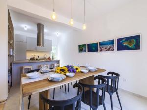 a kitchen and dining room with a wooden table and chairs at Charming Villa with Pool in Šibenik