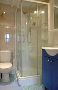 e bagno con doccia, servizi igienici e lavandino. di Hotel Henri IV a Saint-Valéry-en-Caux