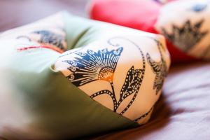 a woman laying on a bed with a flower design on her pillow at Kiyomizu Shukuba in Kyoto