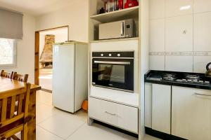 una cocina con estufa y refrigerador en Casa no Centro de Gramado, en Gramado 20 fotos más