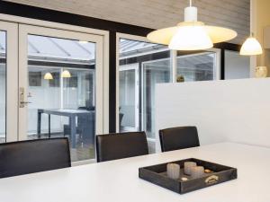 a dining room with a white table with chairs and a dining at 8 person holiday home in Hirtshals-By Traum in Hirtshals +27 photos