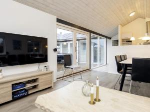 a living room with a large tv and a table at 8 person holiday home in Hirtshals-By Traum in Hirtshals