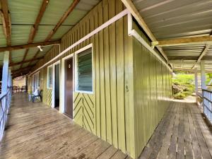 an empty porch of a house with a wooden deck at Rustic B&B in Ranau