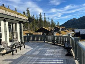 un ponte con due panchine su una casa con montagne di Ornenipa Lodge - stor flott hytte med 6 sov og 2 bad a Gaustablikk