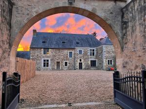 an archway leading to a large stone house at Seigneurie du Bois Moreau in Durtal
