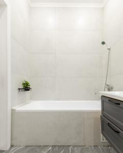 a white bathroom with a tub and a sink at Апартаменты возле Хан-Шатыра и Ботанического Сада in Astana +40 photos