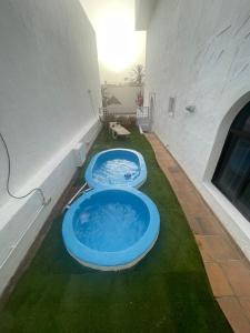 two blue tubs sitting on the grass in a building at Apartamento con jardín y pequeña piscina privada para refrescarse in Maspalomas
