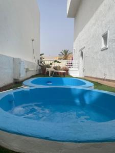 a large blue pool in front of a building at Apartamento con jardín y pequeña piscina privada para refrescarse in Maspalomas