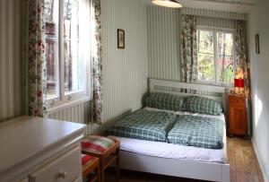 Un dormitorio con una cama y dos ventanas. en Liebenswertes Sommerhaus in Seenähe, en Bad Saarow