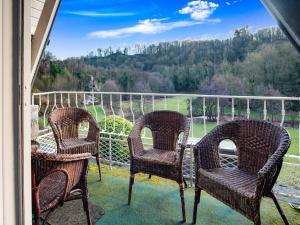 three chairs on a porch with a view of a field at Luxury Pool Villa in Sosoye in Sosoye