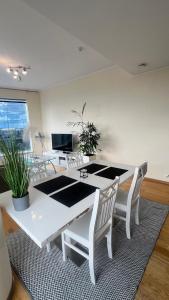 une salle à manger blanche avec une table et des chaises blanches dans l'établissement Luxury Nightlights NELLI Apartment, à Tallinn
