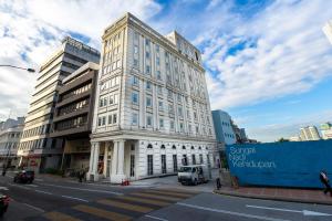 um edifício branco alto numa rua da cidade em Avenue J Hotel, Central Market em Kuala Lumpur