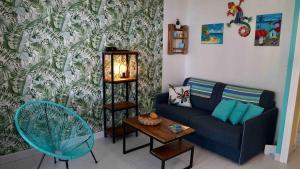 a living room with a couch and a table at Tikaz Turkoiz T3 Manganao in Saint-François