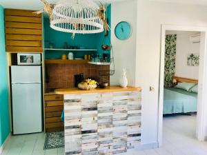 a kitchen with a large wooden chest of drawers at Tikaz Turkoiz T3 Manganao in Saint-François +21 photos