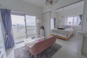 a white bedroom with a bed and a window at 沖縄SunSea海景酒店整套公寓 那霸机场20分钟车程 
