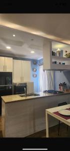 een keuken met witte kasten en een aanrechtblad bij Maison Verde Madinaty in Banī Ghālib