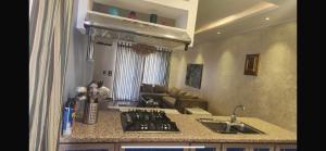 een keuken met een spoelbak en een fornuis bovenste oven bij Maison Verde Madinaty in Banī Ghālib