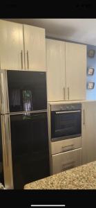 een keuken met witte kasten en een zwart apparaat bij Maison Verde Madinaty in Banī Ghālib +2 foto's